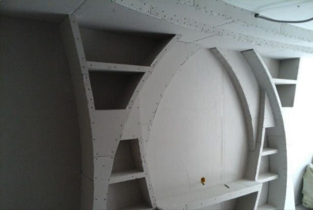 Декоративная стенка из гипсокартона с открытыми полками и арочными сводами