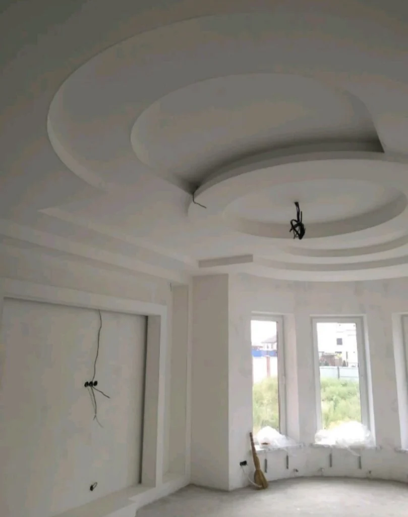 Многоуровневый круглый потолок из гипсокартона в светлом интерьере с эркером